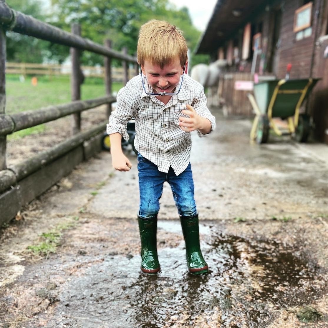 kid jumping in a puddle